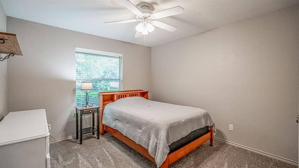 511 Casas Del Norte Court, Granbury, TX 76049 Neutral-toned interior featuring carpeting, a ceiling fan, and a window treatments