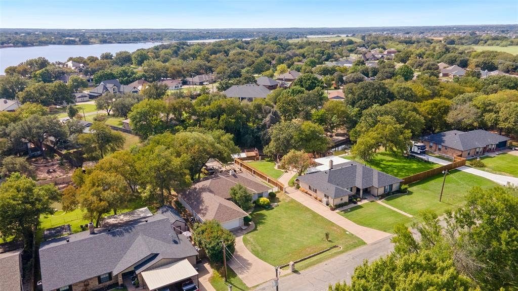 511 Casas Del Norte Court, Granbury, TX 76049 Aerial perspective of a residential neighborhood featuring established tree canopy, manicured lawns, and proximity to Lake Granbury mainbody