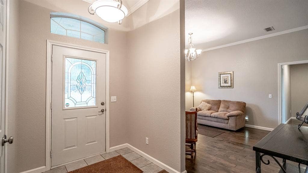 511 Casas Del Norte Court, Granbury, TX 76049 Entryway featuring an arched transom window, a glass-panel door, ceramic tile flooring, and crown molding