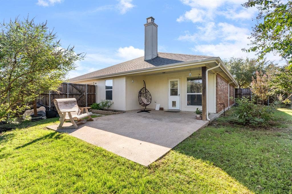 2750 Chalmers Court, Rockwall, TX 75032 The large backyard features a large patio, multiple trees, and a Board on Board fence