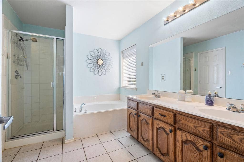 2750 Chalmers Court, Rockwall, TX 75032 The primary suite includes an ensuite bath with double sinks, a relaxing soaking tub, a separate shower, and a large walk in closet.