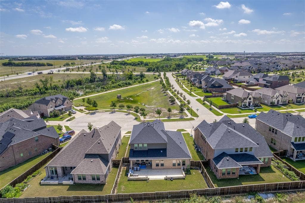 16931 Maple Bend Drive, Frisco, TX 75035 Aerial view of suburban property featuring a brick and masonry exterior, asphalt shingle roof, rear concrete patio, and fenced backyard
