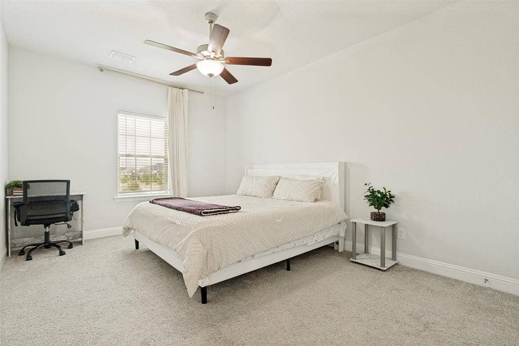 16931 Maple Bend Drive, Frisco, TX 75035 Neutral-toned carpeting, multi-blade ceiling fan with integrated lighting, and window featuring horizontal blinds