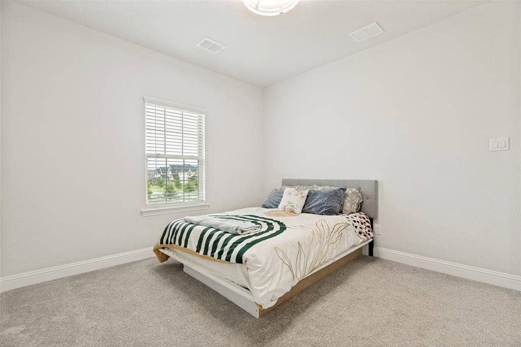 16931 Maple Bend Drive, Frisco, TX 75035 Neutral-toned wall finish, high ceilings, carpeting, and a single-pane window with interior blinds