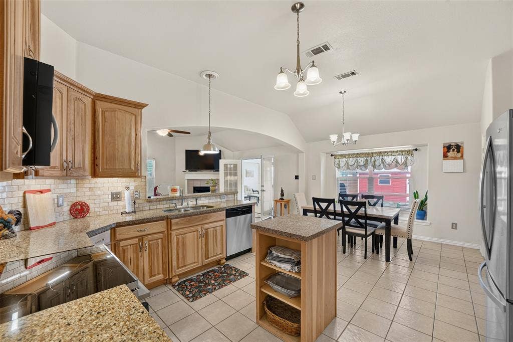 8700 Broken Bow Drive, Greenville, TX 75402 Large entertainment Kitchen featuring Shenandoah cabinetry, Silestone quartz countertops, tile backsplash, center island, and vaulted ceilings