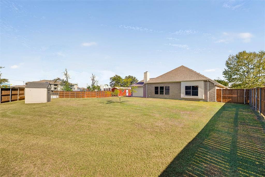 8700 Broken Bow Drive, Greenville, TX 75402 Expansive backyard featuring the detached structures and a cute mimosa tree flourishing in the middle of the yard. MORE than enough room for a huge outdoor living center!