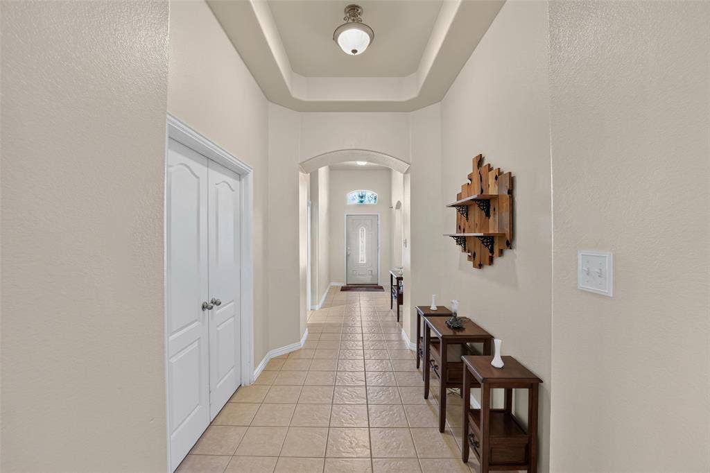 8700 Broken Bow Drive, Greenville, TX 75402 Welcome In. There are lots of surprises and upgrades. Let's start with this beautiful Grand Entryway featuring a tray ceiling, arched architectural opening, neutral tile flooring, and a glass-inset exterior door. The double doors are to the bonus room/study.