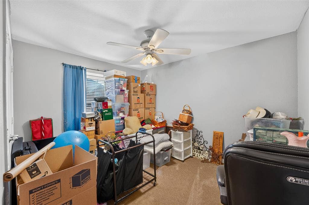 8700 Broken Bow Drive, Greenville, TX 75402 Sec. bedroom with ceiling fan currently being used as a staging area for the move.