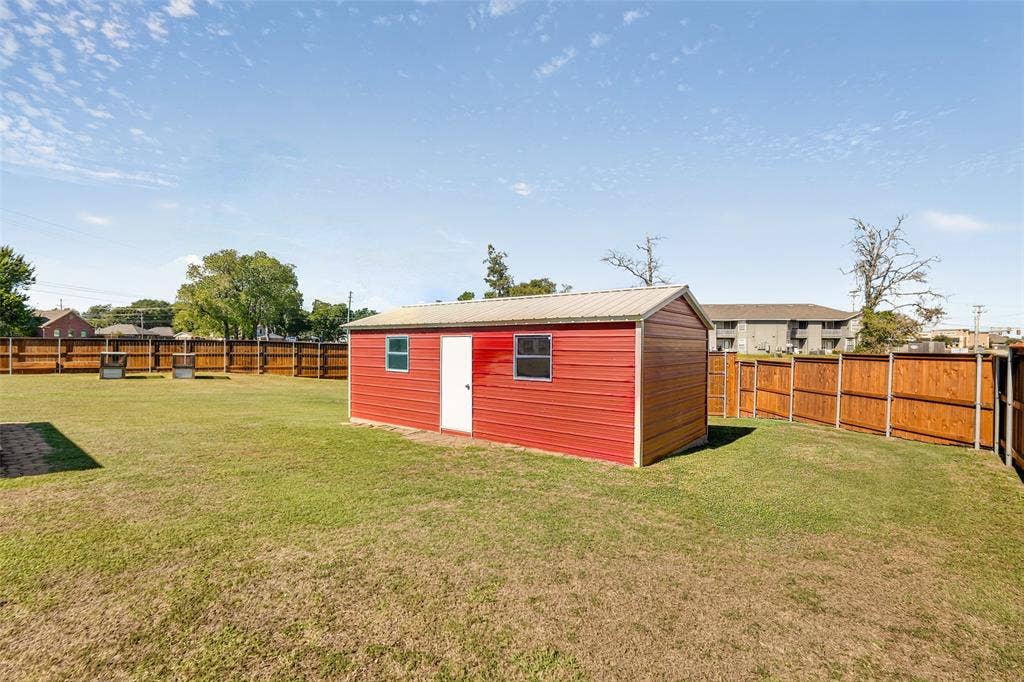 8700 Broken Bow Drive, Greenville, TX 75402 Detached workshop with metal siding, metal roof, and two windows.