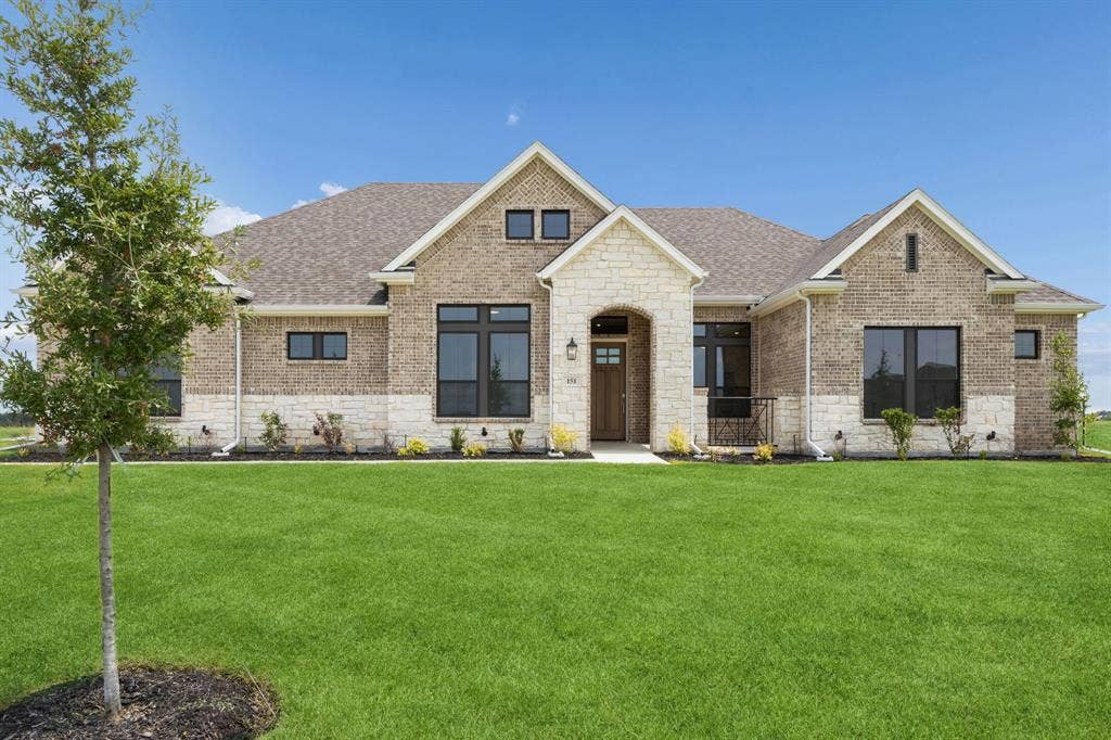 151 Quiet Waters Way, Waxahachie, TX 75165 Brick and stone exterior facade featuring a covered entryway, multi-gabled roofline, and dark-framed windows