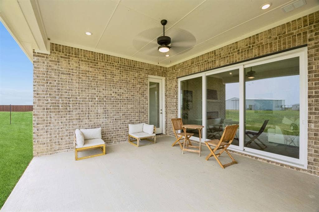 151 Quiet Waters Way, Waxahachie, TX 75165 Covered patio featuring a brick exterior, concrete flooring, recessed lighting, and a ceiling fan, including large sliding glass doors