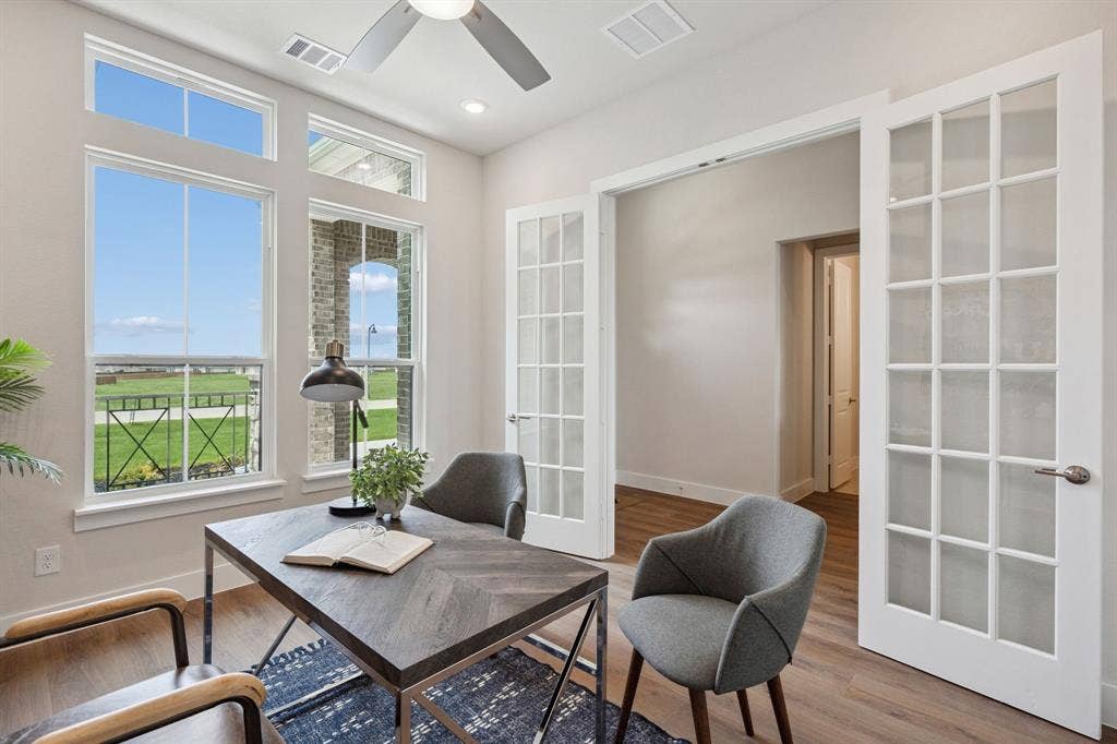 151 Quiet Waters Way, Waxahachie, TX 75165 Room featuring wood-finish flooring, white French doors, tall windows with transoms, and a ceiling fan
