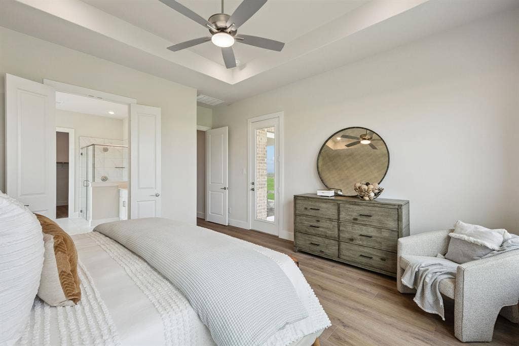 151 Quiet Waters Way, Waxahachie, TX 75165 Tray ceiling with recessed lighting, brushed nickel ceiling fan, wood-finish flooring, and a glass-paneled exterior door