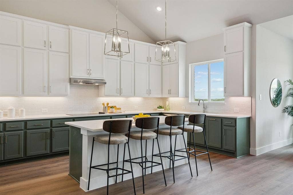 151 Quiet Waters Way, Waxahachie, TX 75165 Kitchen featuring two-tone cabinetry, central island with seating space, stainless steel range hood, stone-finish countertops, and wood-finish flooring