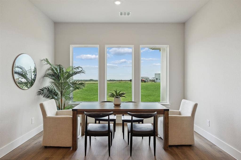 151 Quiet Waters Way, Waxahachie, TX 75165 Triple window configuration with neutral-toned interior walls, wood-finish flooring, and recessed ceiling lighting