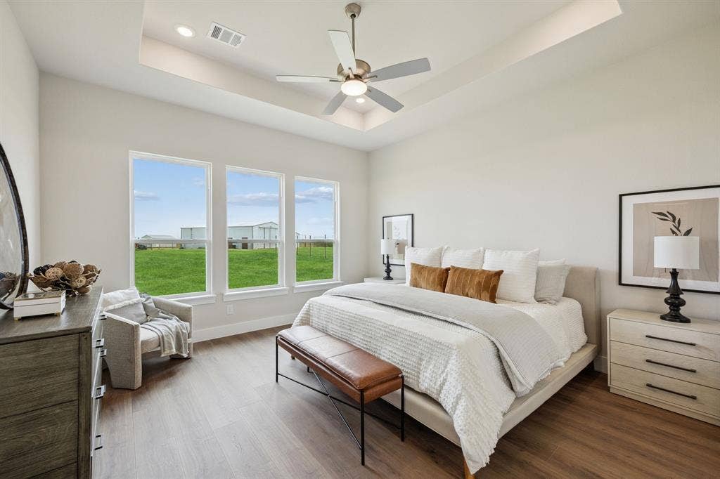 151 Quiet Waters Way, Waxahachie, TX 75165 Tray ceiling, wood-finish flooring, ceiling fan, and large windows with exterior landscape exposure