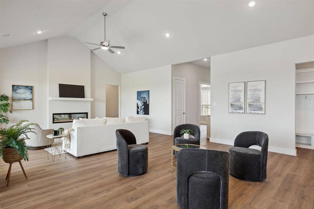 151 Quiet Waters Way, Waxahachie, TX 75165 Vaulted ceilings, linear fireplace with a mantel, wood-finish flooring, recessed lighting, and built-in shelving