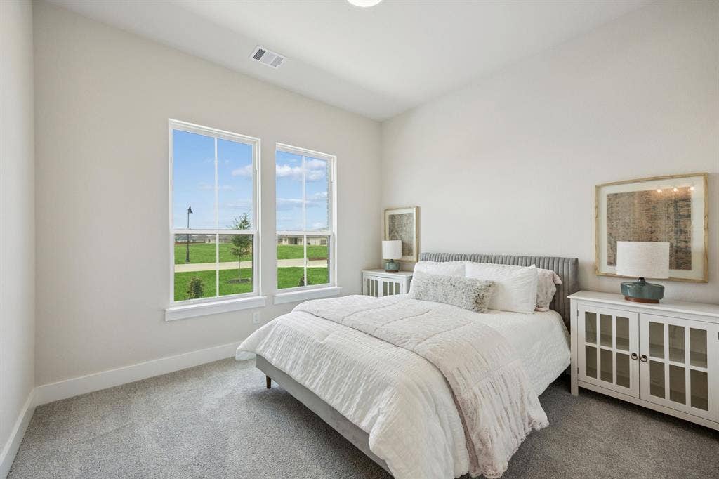 151 Quiet Waters Way, Waxahachie, TX 75165 Neutral-toned interior space featuring high ceilings, wall-to-wall carpeting, and large dual-pane windows with grids
