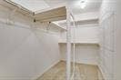 Walk-in closet featuring multi-level white wire shelving and light-toned wood-finish flooring