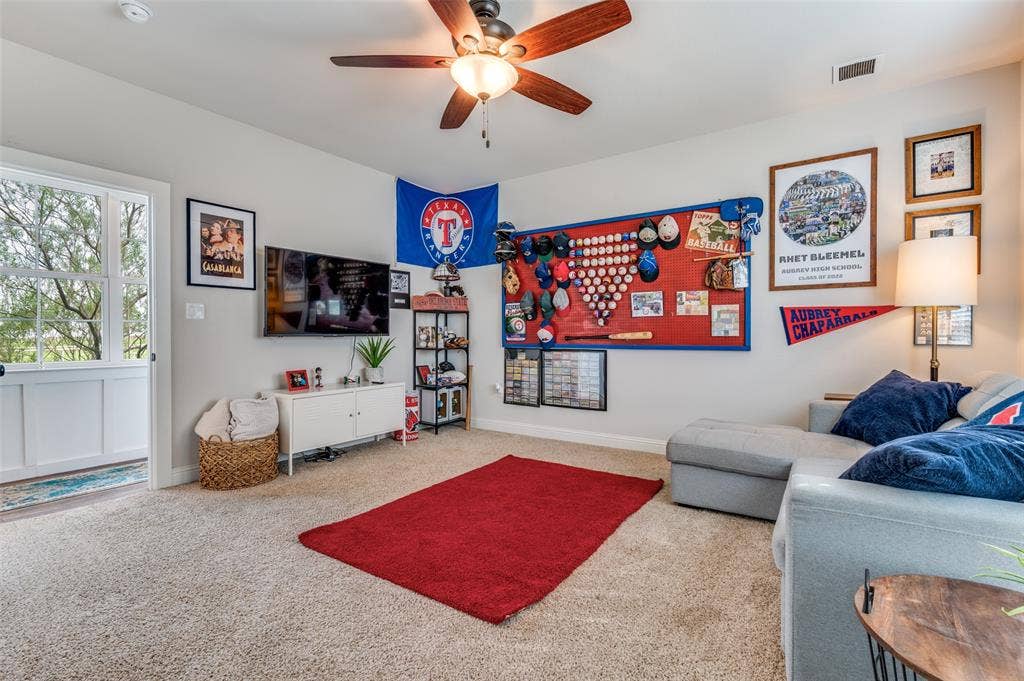 Neutral-toned interior featuring plush carpeting, a multi-blade ceiling fan with integrated lighting, and a glass-paneled exterior door