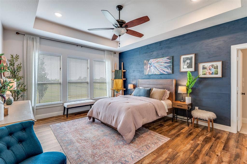Tray ceiling with recessed lighting, wood-finish flooring, and a dark-toned horizontal wood plank accent wall