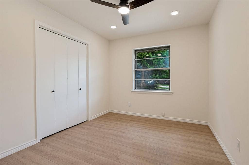 417 Keats Circle, Irving, TX 75061 Neutral-toned room featuring wood-finish flooring, a double-door closet, recessed lighting, and a ceiling fan with integrated light fixture