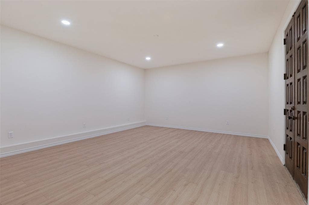 417 Keats Circle, Irving, TX 75061 Neutral-toned interior space featuring wood-finish flooring, recessed lighting, and dark-stained double doors