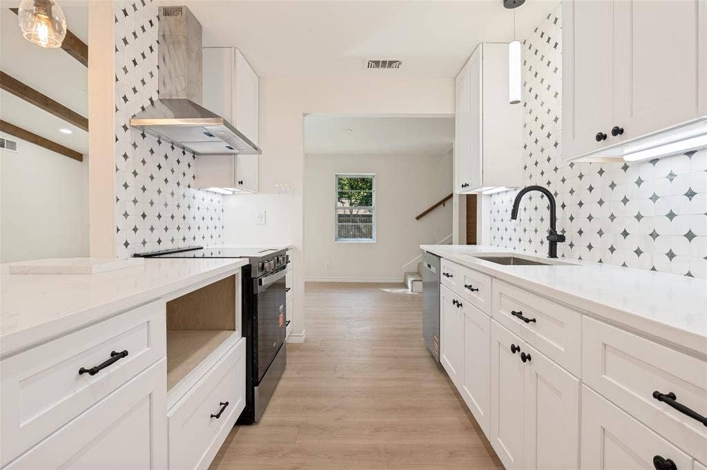 417 Keats Circle, Irving, TX 75061 Kitchen featuring white shaker-style cabinetry, solid-surface countertops, decorative geometric backsplash tile, wood-finish flooring, and a stainless steel chimney-style range hood