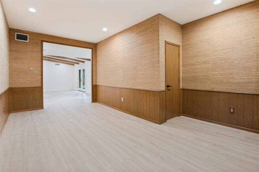 417 Keats Circle, Irving, TX 75061 Textured wall coverings, horizontal wood-panel wainscoting, light wood-finish flooring, and recessed ceiling lighting