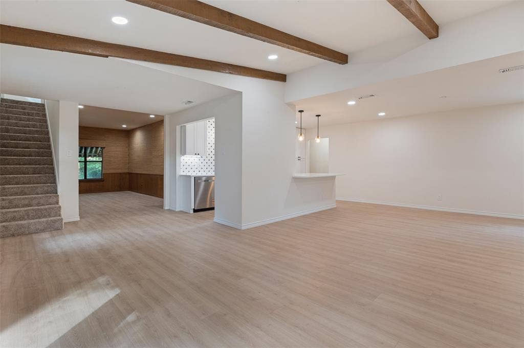 417 Keats Circle, Irving, TX 75061 Open-concept interior featuring wood-finish flooring, exposed ceiling beams, recessed lighting, and a breakfast bar with dual pendant lights
