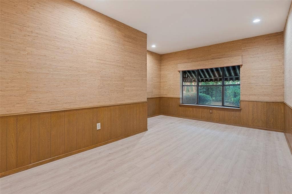 417 Keats Circle, Irving, TX 75061 Interior room featuring textured wall coverings, wood-panel wainscoting, wood-finish flooring, recessed lighting, and a multi-pane window with a fabric valance