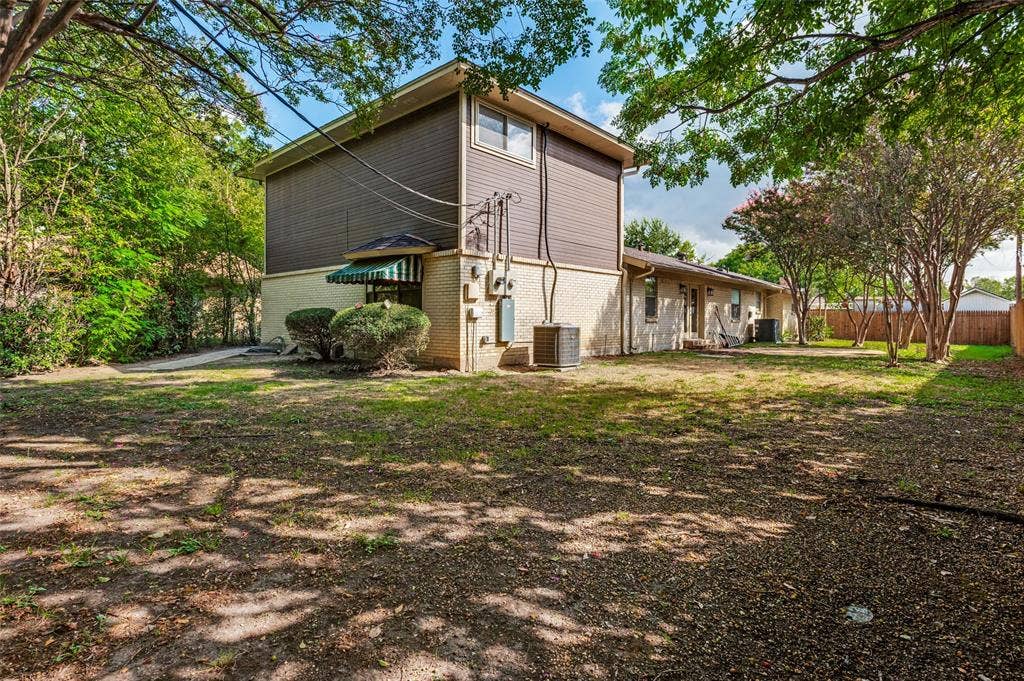 417 Keats Circle, Irving, TX 75061 Exterior featuring a two-story elevation, horizontal siding, masonry base, and a fenced backyard with mature trees