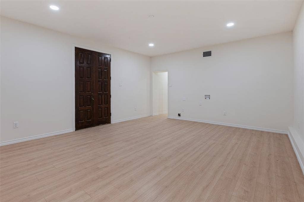 417 Keats Circle, Irving, TX 75061 Interior space featuring neutral wall tones, wood-finish flooring, recessed lighting, and a dark-stained wood-paneled double door