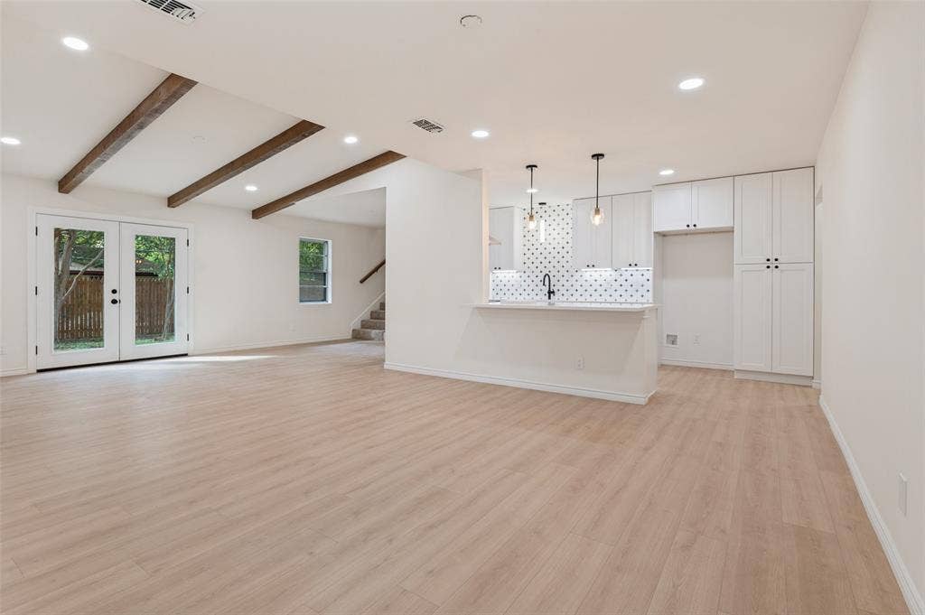 417 Keats Circle, Irving, TX 75061 Open-concept space featuring wood-finish flooring, exposed ceiling beams, custom shaker-style cabinetry, a patterned tile backsplash, and recessed lighting