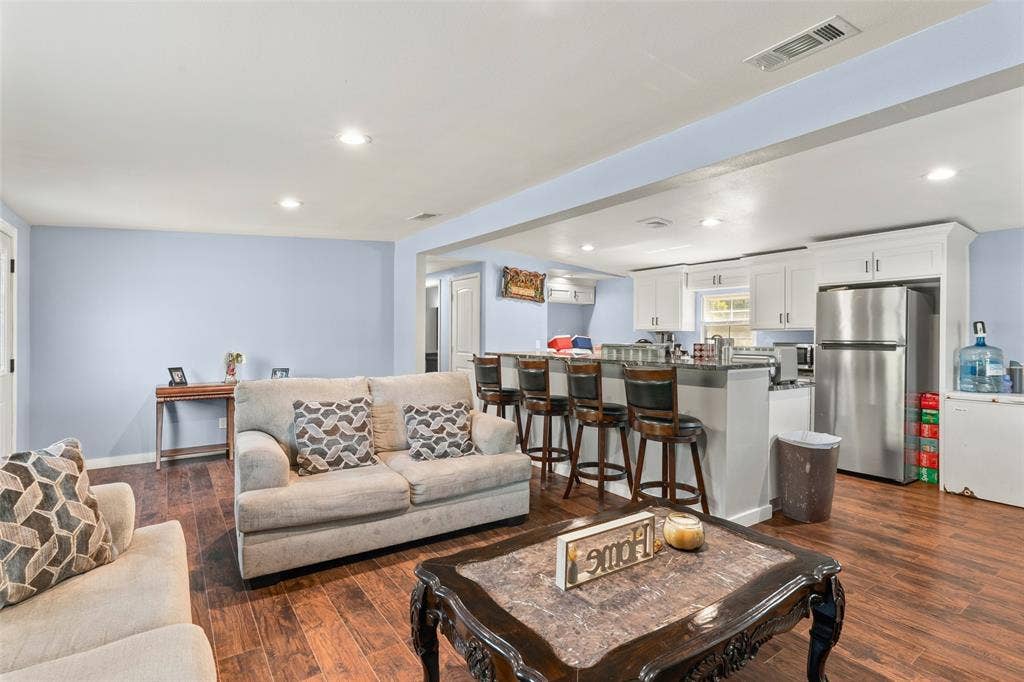 1219 Green Tree Acres Road, Kemp, TX 75143 Open-concept living space featuring wood-finish flooring, recessed lighting, and kitchen cabinetry with a breakfast bar