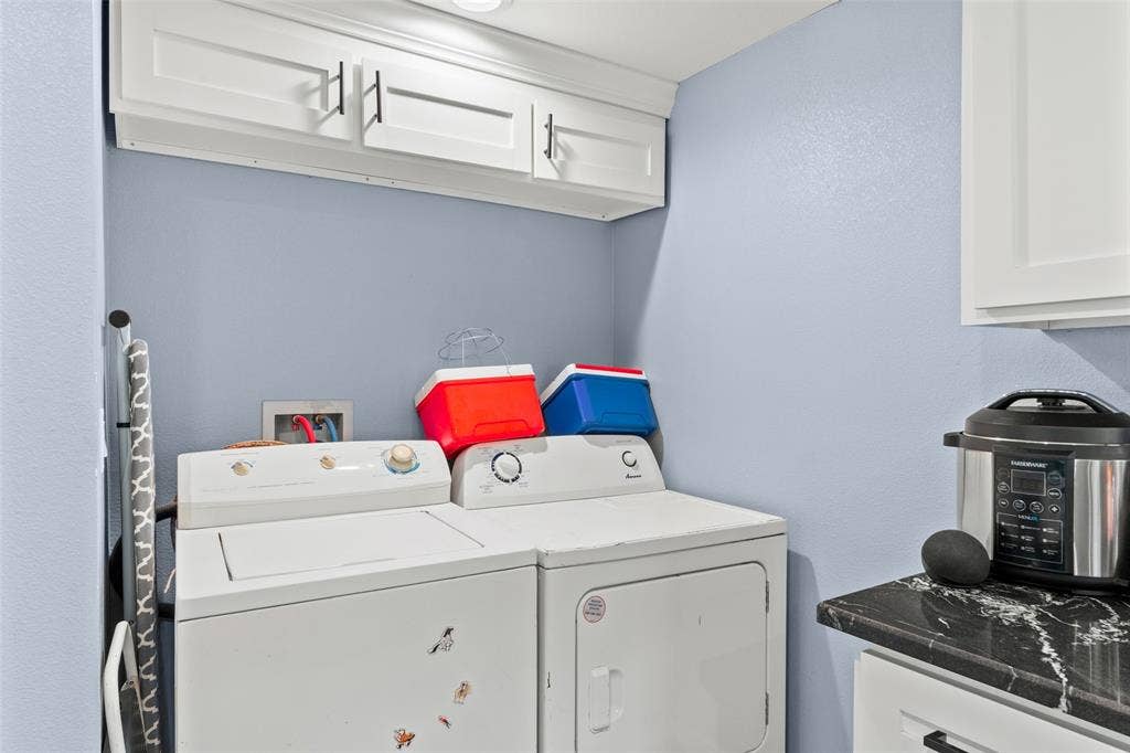 1219 Green Tree Acres Road, Kemp, TX 75143 Utility space featuring white shaker-style wall-mounted cabinetry with matte black hardware, stone-finish countertops, and recessed ceiling lighting