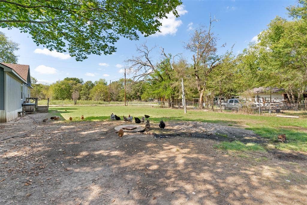 1219 Green Tree Acres Road, Kemp, TX 75143 Expansive backyard featuring a large grass lawn, mature trees, and perimeter fencing
