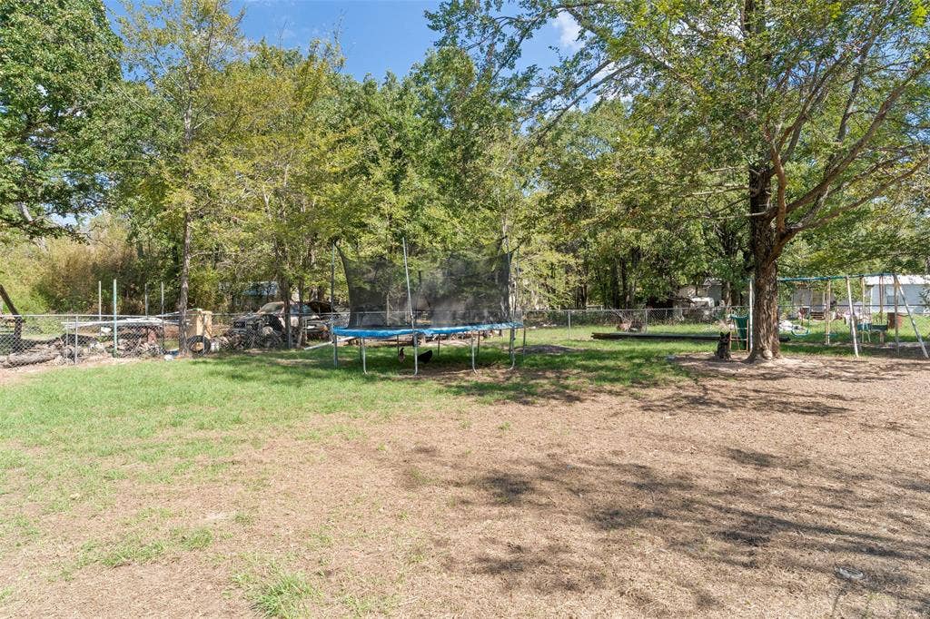1219 Green Tree Acres Road, Kemp, TX 75143 Expansive lot featuring mature trees, partial grass lawn, and a perimeter chain-link fence