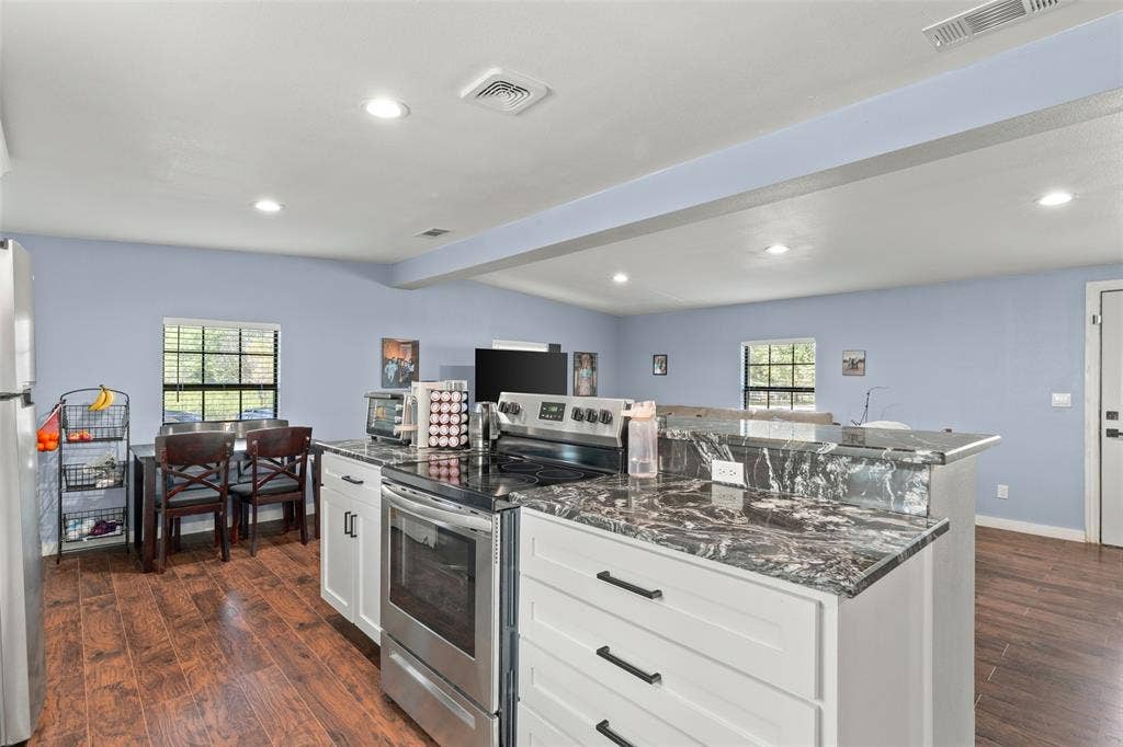 1219 Green Tree Acres Road, Kemp, TX 75143 Kitchen featuring white cabinetry, stone-finish countertops, stainless steel appliances, and wood-finish flooring