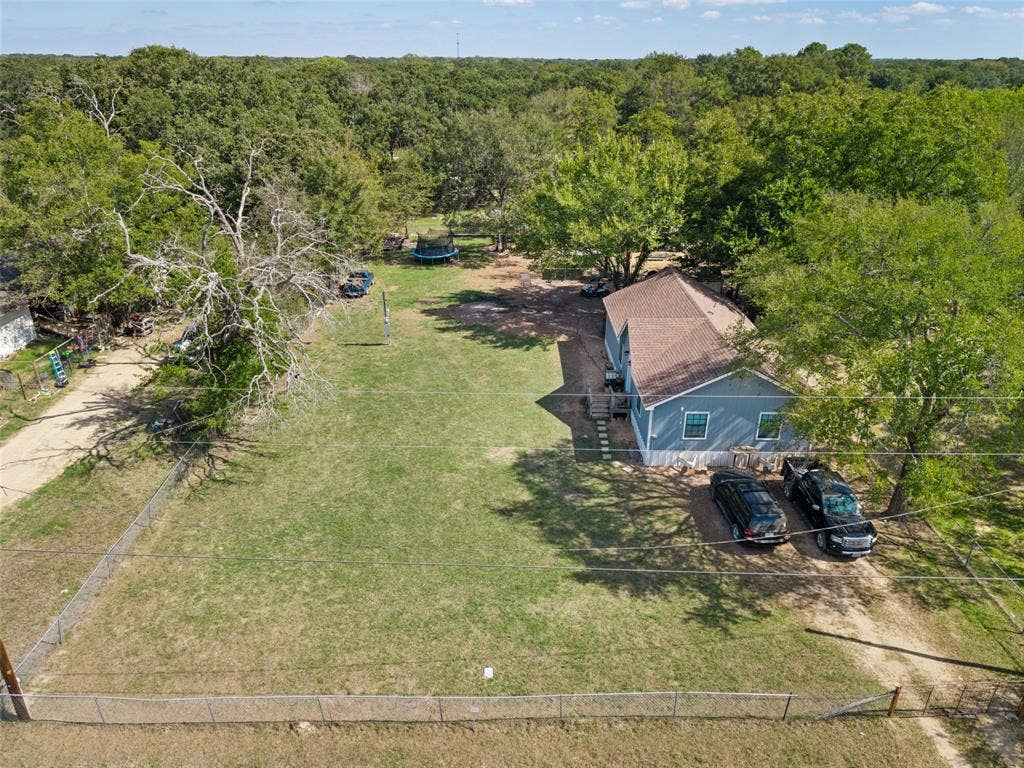 1219 Green Tree Acres Road, Kemp, TX 75143 Expansive lot featuring mature trees, a chain-link fenced perimeter, and a detached structure with a pitched shingle roof
