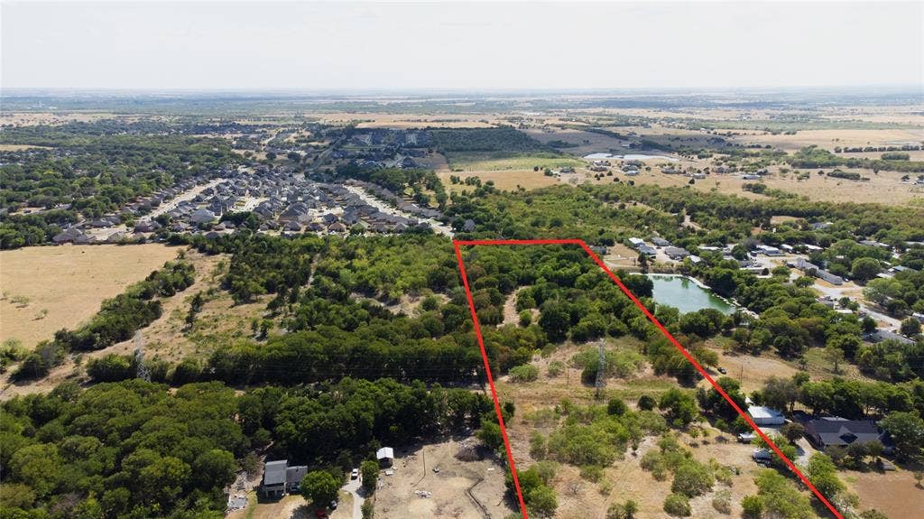 Expansive acreage featuring mature trees, natural vegetation, and a private pond