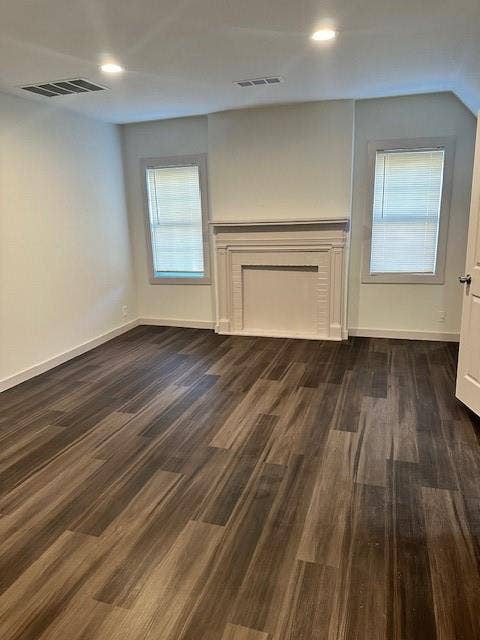 1613 Campbell Street, #A, Commerce, TX 75428 Wood-finish flooring, white decorative fireplace mantel, recessed ceiling lighting, and dual windows