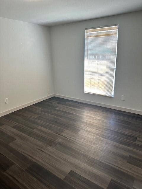 1613 Campbell Street, #A, Commerce, TX 75428 Neutral-toned interior space featuring wood-finish flooring, crisp white walls, and a single window with horizontal blinds