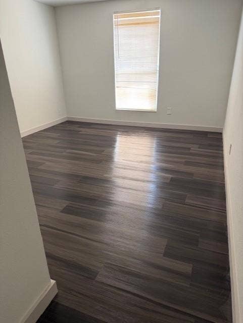 1613 Campbell Street, #A, Commerce, TX 75428 Room featuring wood-finish flooring, neutral walls, and a single vertical window with installed blinds