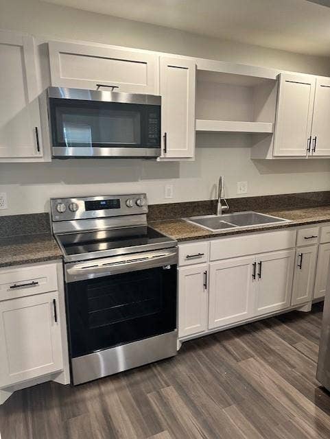 1613 Campbell Street, #A, Commerce, TX 75428 Kitchen featuring white shaker-style cabinetry, stainless steel appliances, dark stone-finish countertops, integrated microwave, and wood-finish flooring