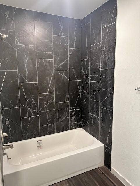 1613 Campbell Street, #A, Commerce, TX 75428 Bathtub surround featuring large-format, dark stone-finish tile with white veining, polished chrome faucet, and integrated shower head