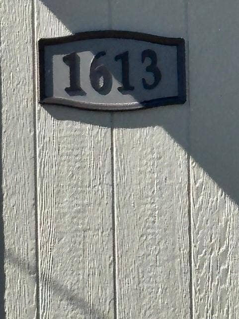1613 Campbell Street, #A, Commerce, TX 75428 Custom address plaque featuring raised black numerals mounted on vertical wood-texture paneling