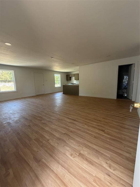 Open-concept interior featuring wood-finish flooring, recessed lighting, and multiple windows