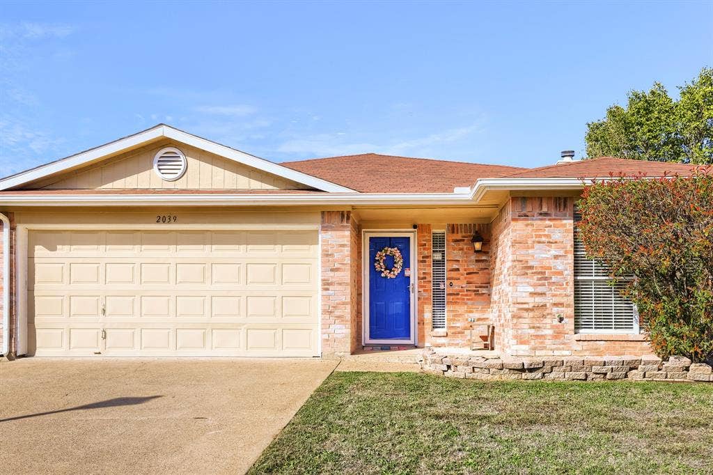 2039 Angelica Way, Dallas, TX 75217 Single-story exterior featuring a brick and siding facade, attached two-car garage, recessed entryway, and stacked-stone garden border