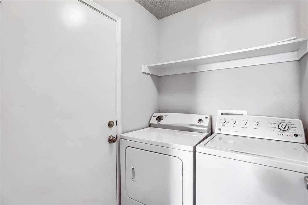 2039 Angelica Way, Dallas, TX 75217 Utility area featuring a wall-mounted shelving unit and a door with metallic hardware